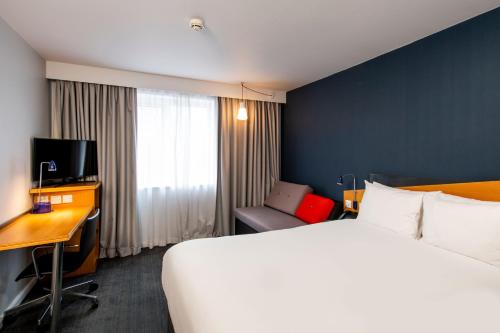 ニューカッスル・アポン・タインにあるHoliday Inn Express Newcastle Gateshead, an IHG Hotelの大きなベッドとデスクが備わるホテルルームです。