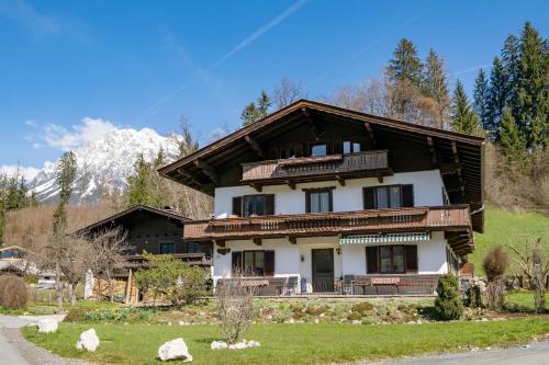una casa en una colina con montañas al fondo en Im Riederhof, en Going