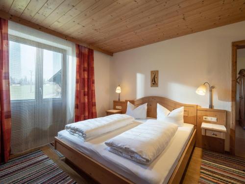 a bedroom with a large bed and a window at Im Riederhof in Going am Wilden Kaiser