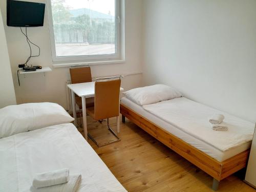 a room with two beds and a table and a window at Agro Complex Apartments in Nitra