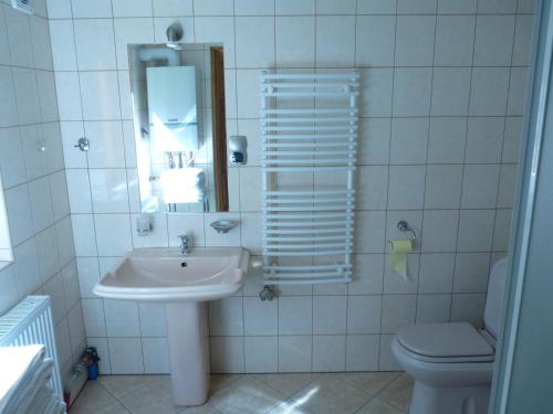 a white bathroom with a sink and a toilet at DOMKI CZYRNA SZCZYRK in Szczyrk