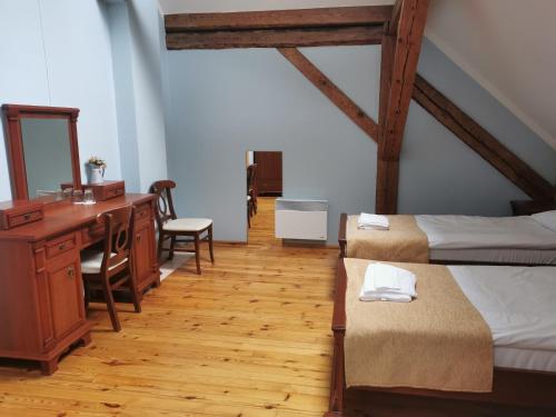 Zimmer mit 3 Betten, einem Schreibtisch und einem Waschtisch in der Unterkunft Palmse Manor Guesthouse in Palmse