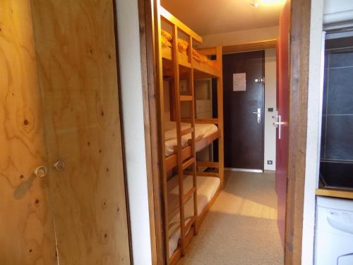 Cette chambre comprend des lits superposés et une porte. dans l'établissement Studio Les Orres 1650, aux Orres