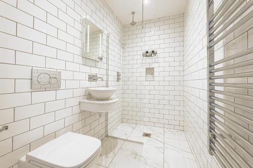 a white bathroom with a toilet and a sink at The Royal Bell Apartments - Central Bromley in Bromley
