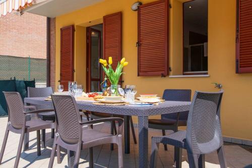 een tafel en stoelen op een patio bij Rossellini Home a Gabicce Mare by Yohome in Gabicce Mare