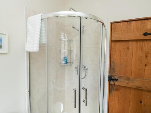 a shower with a glass door in a bathroom at Gloccamaura in Newton Abbot