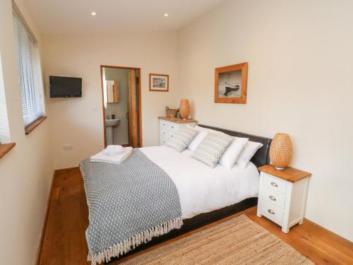 a bedroom with a large bed and a television at Gloccamaura in Newton Abbot