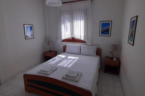 una camera da letto con un grande letto con due asciugamani di Helen's house a Pefkohori