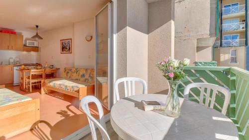 um quarto com uma mesa com um vaso de flores em Vacancéole - Les Balcons du Soleil em Germ