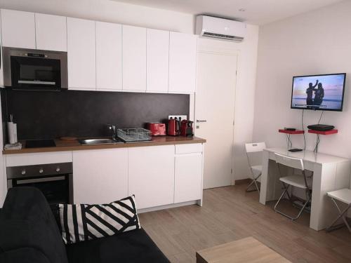 a kitchen with white cabinets and a desk in a room at COSY 2P A 5 MINUTES A PIED DE LA MER ET DU CENTRE in Menton