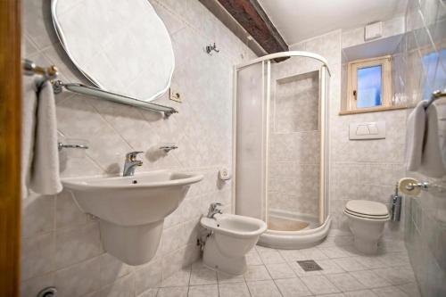 a bathroom with a sink and a toilet and a shower at Apartments Casa Rubeus Rovinj in Rovinj