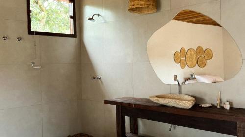 ein Bad mit einem Waschbecken und einem Spiegel in der Unterkunft Pousada Piratas do Barro Branco in Pedregulho