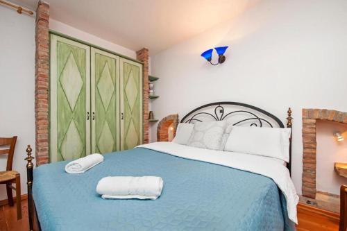 a bedroom with a blue bed with two towels on it at Apartments Casa Rubeus Rovinj in Rovinj