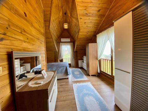 a bedroom in a log cabin with a bed and a desk at Ozgur Villa Home in Uğurlu