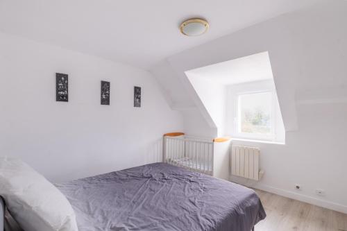 ein weißes Schlafzimmer mit einem Bett und einem Fenster in der Unterkunft Seabird - Belle maison pour 8 in Camoël