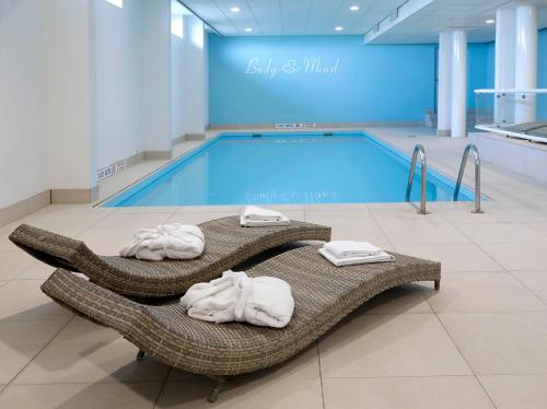 een zwembad met handdoeken en een zwembad bij Churchill hotel Terneuzen in Terneuzen
