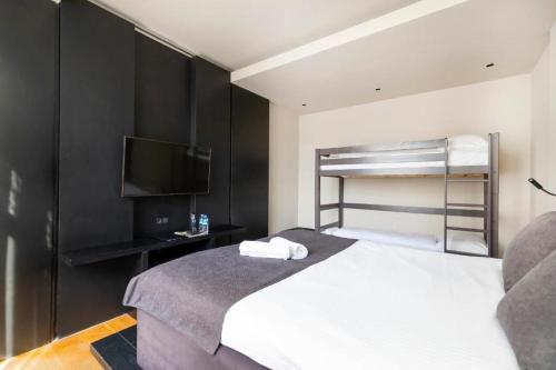 a bedroom with a bed and a bunk bed with a television at AmsterHome Hotel in Amsterdam