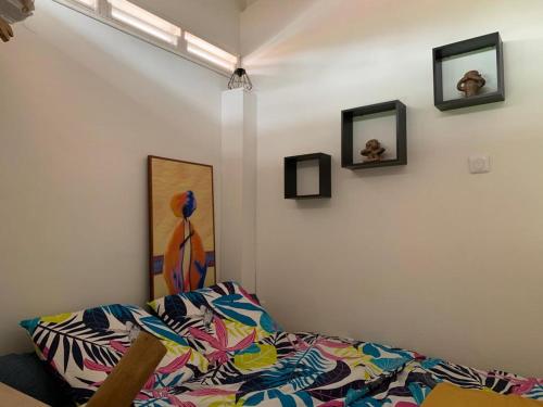 Habitación con cama y cuadros en la pared. en Studioloc'Martinique, en Les Trois-Îlets