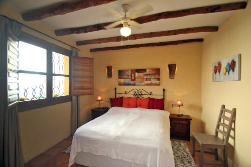 1 dormitorio con cama blanca y ventana en Mi Joya, en Montejaque
