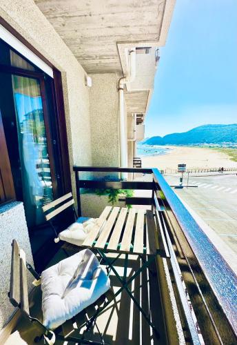 a balcony with a bench and a view of the beach at Apartamentos Noja Playa in Noja