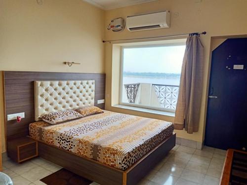 a bedroom with a bed and a large window at Scindhia Guest House in Varanasi