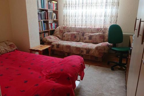 a living room with a red bed and a couch at Apartment 4 Kullat in Prizren