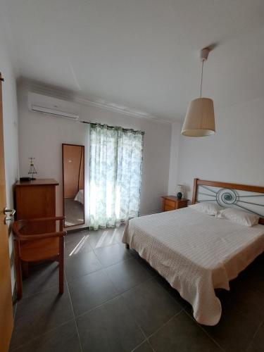 Un dormitorio con una cama y una mesa y una ventana. en Villa Caballero, en Alfundão