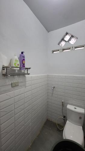 a white bathroom with a toilet in a room at Alceo Homestay Pandan in Halangan