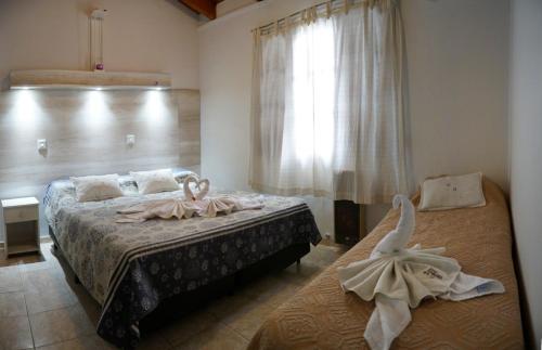 a bedroom with two beds with towels on them at Aranjuez Real in Villa Carlos Paz