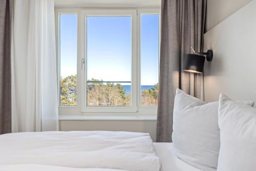 1 dormitorio con cama blanca y ventana en Strandresidenzen Strandresidenzen Haus Dänholm, en Binz