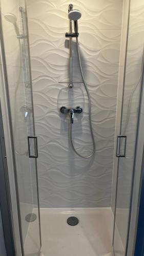 a shower with a glass door in a bathroom at Appartement St Amant Tallende in Saint-Amant-Tallende