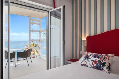 a bedroom with a bed and a view of the ocean at Seaside Hotel in Capo dʼOrlando