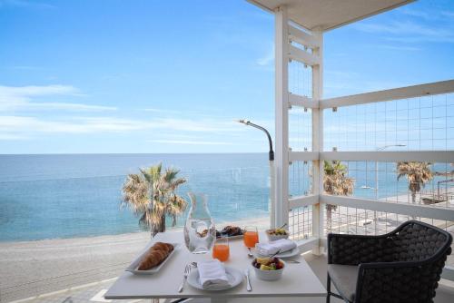een tafel met eten en uitzicht op de oceaan bij Seaside Hotel in Capo dʼOrlando