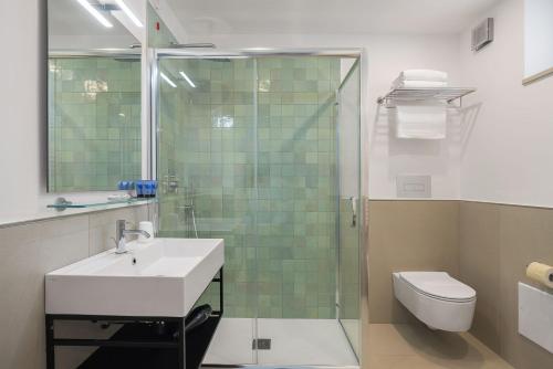 a bathroom with a sink and a shower and a toilet at Seaside Hotel in Capo dʼOrlando