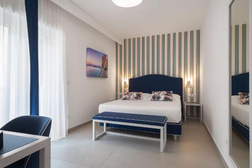 a bedroom with a bed and a chair in a room at Seaside Hotel in Capo dʼOrlando