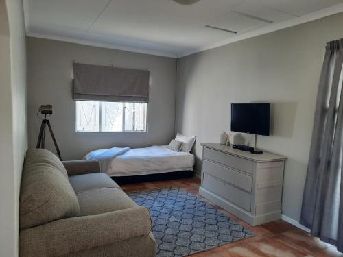 a living room with a couch and a bed at Little Milner Cottage in Queenstown