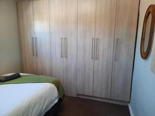 a bedroom with a bed and wooden cabinets at Little Milner Cottage in Queenstown