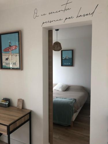 une chambre avec un lit et un panneau sur le mur dans l'établissement Les pois sont verts, à La Rochelle