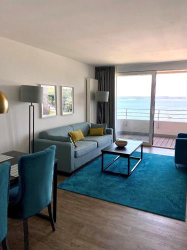 a living room with a couch and a table at Intermar Hotel & Apartments in Glücksburg