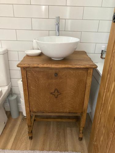 a bathroom with a sink on top of a wooden dresser at Cosy 2 bed terraced house in Conwy in Conwy