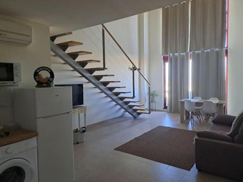 a living room with a staircase and a living room with a table at Acogedor loftcon garaje a 10min del aeropuerto in Madrid