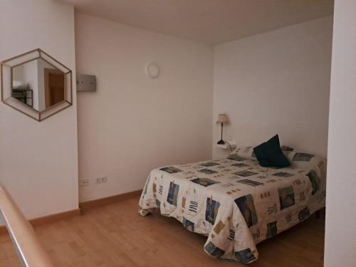 1 dormitorio con cama y espejo en la pared en Acogedor loftcon garaje a 10min del aeropuerto, en Madrid
