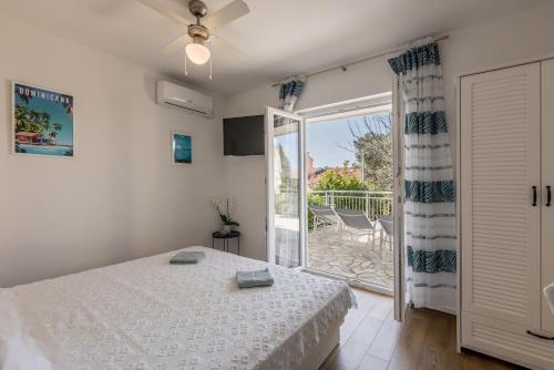 Schlafzimmer mit einem Bett und einer Glasschiebetür in der Unterkunft Seaside Sanctuary - Modern 3 Bedroom and 3 Bathroom Apartment 60m from Beach in Novalja