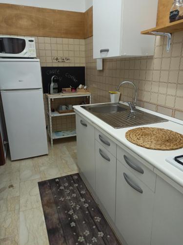 La cuisine est équipée d'un évier et d'un réfrigérateur blanc. dans l'établissement Casa vacanza Melf, à Terrasini