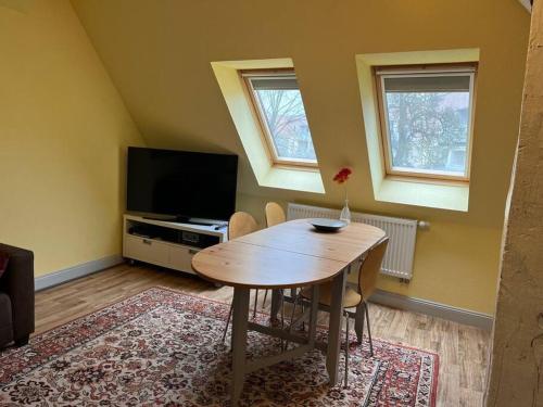 uma sala de estar com uma mesa de madeira e uma televisão em Ferienwohnung - Schweriner Altstadt - FeWo 4 em Schwerin