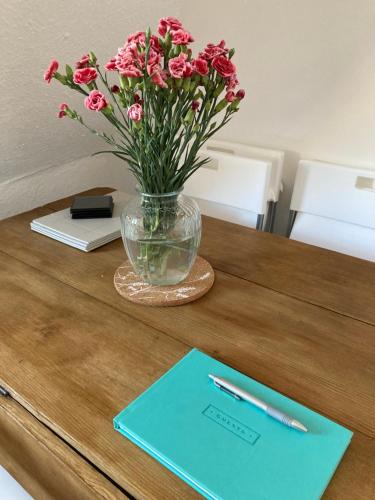 a vase of pink flowers sitting on a table at Cosy 2 bed terraced house in Conwy in Conwy