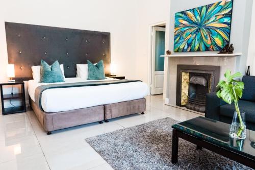 a bedroom with a large bed and a fireplace at 4 on Varneys Guest House - We have uninterrupted power in Cape Town