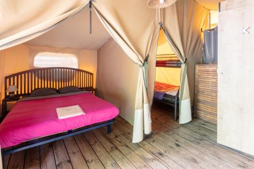 une chambre avec un lit dans une tente dans l'établissement Camping Lou Cabasson, à Bormes-les-Mimosas