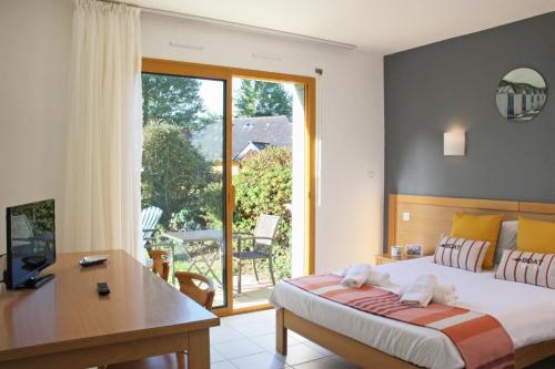 - une chambre avec un lit, un bureau et une fenêtre dans l'établissement Azureva Tregunc, à Trégunc