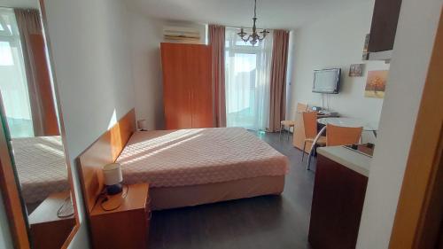 a hotel room with a bed and a desk and a kitchen at Sunny Beach Studio in Apartcomplex Solmarine in Sunny Beach